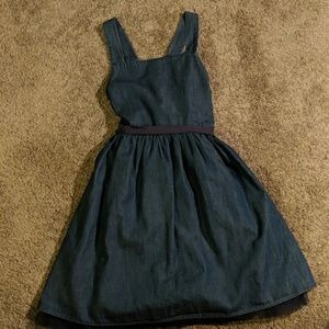 A blue denim looking dress with ribbon and ruffles